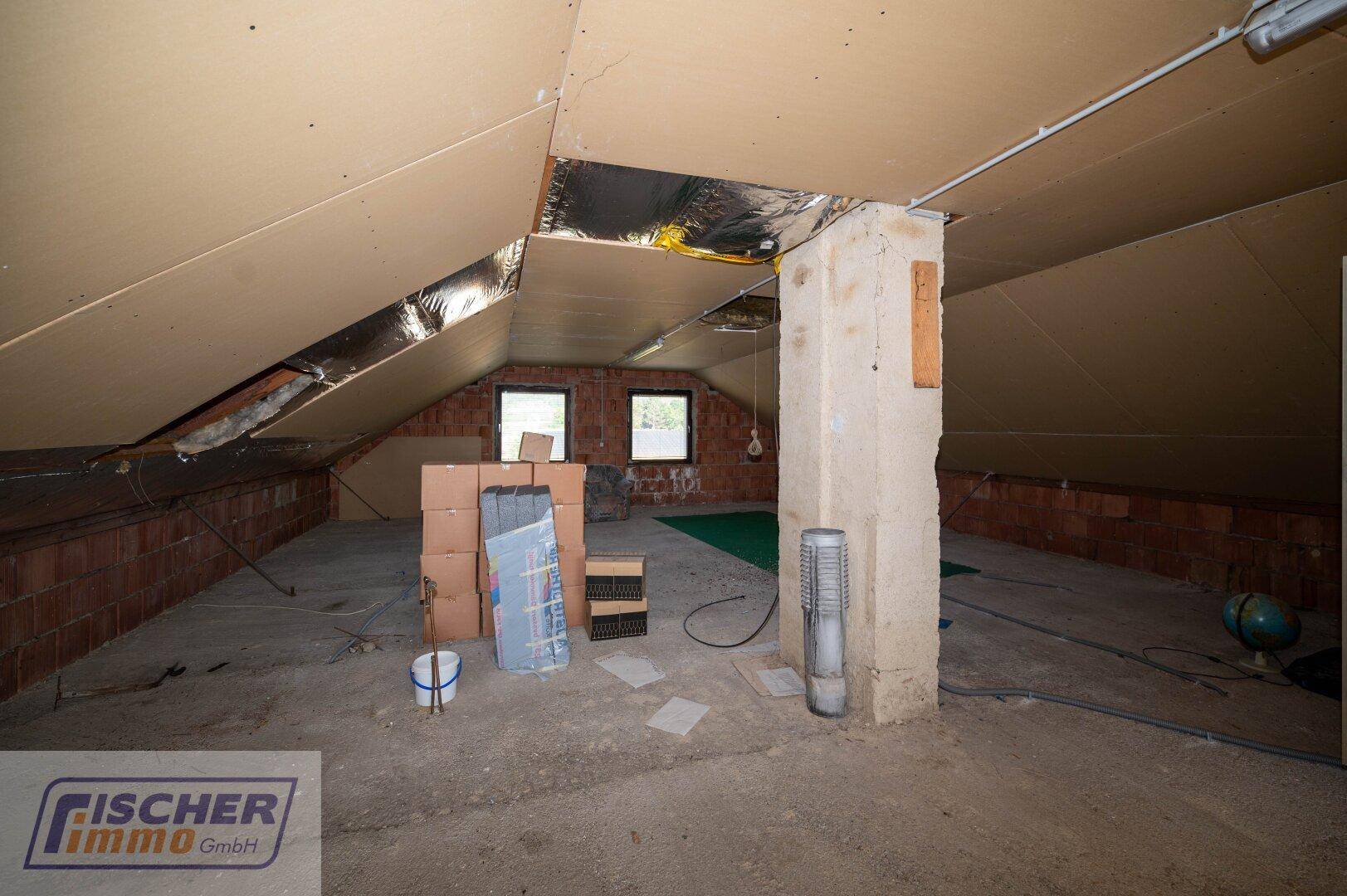 Geräumiger Dachboden mit sichtbaren Ziegelwänden und Potenzial zum Ausbau.
