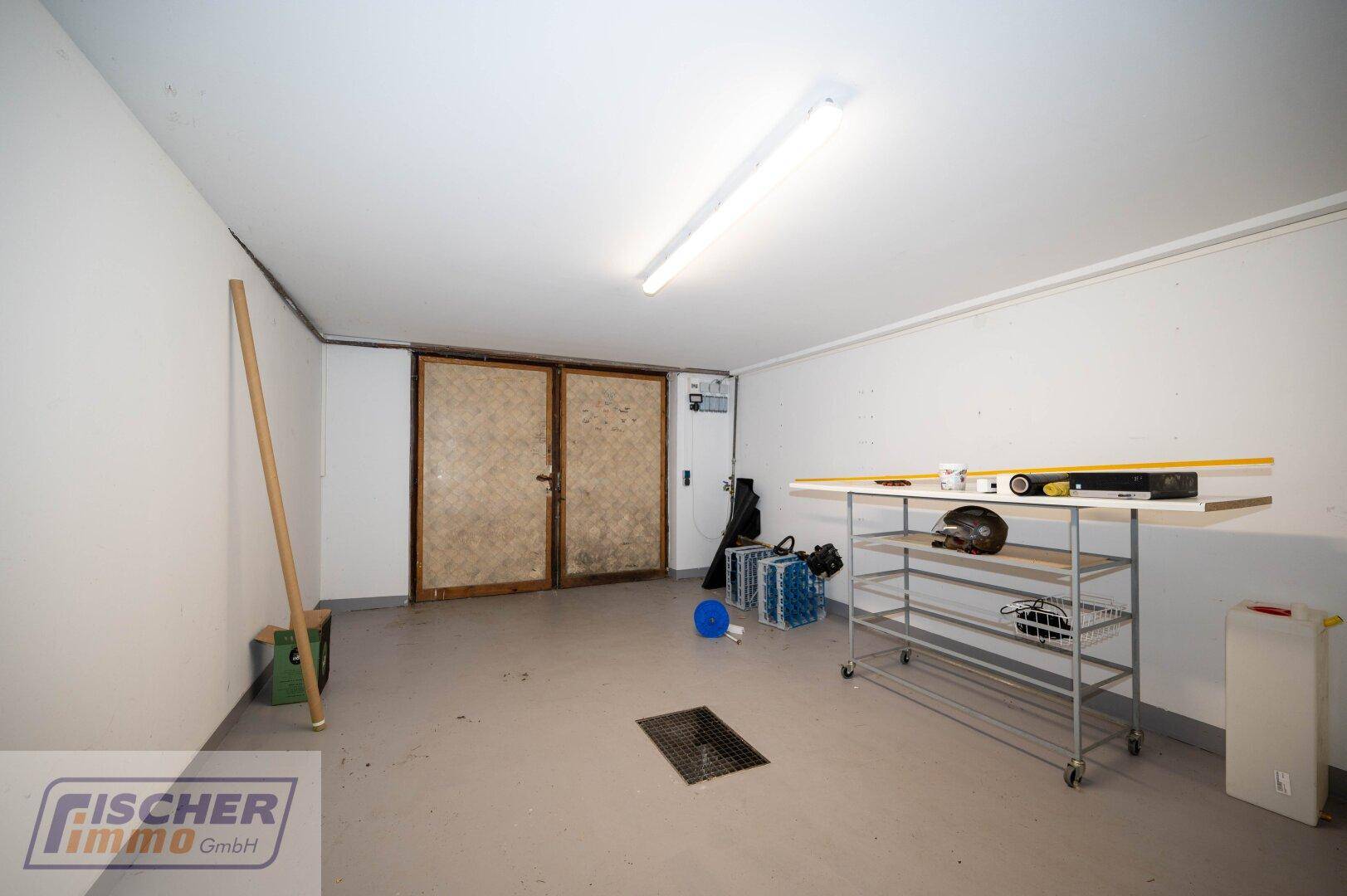 Große Garage oder Lagerraum mit Betonboden und robusten Doppeltüren.