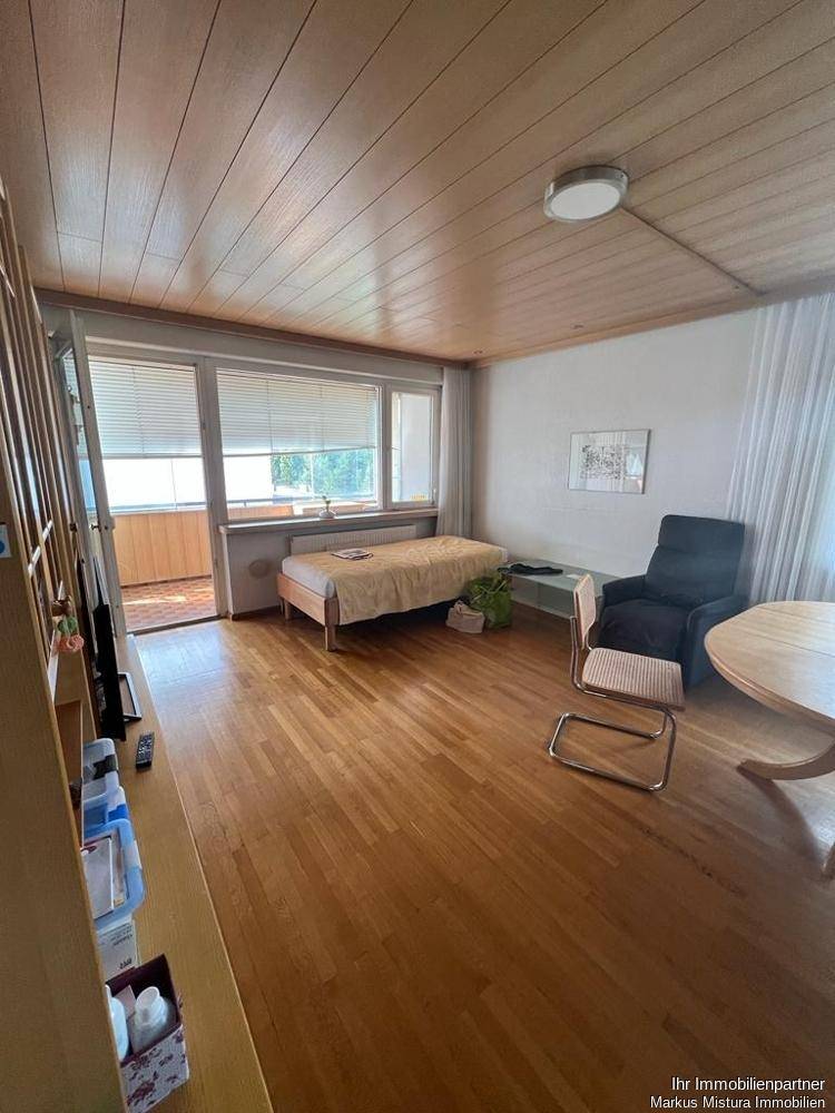 Helles Schlafzimmer mit Holzfußboden, Holzdecke und direktem Zugang zum Balkon.