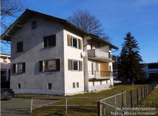 Ansicht des Gebäudes von der Seite mit Balkonen und Fensterläden unter blauem Himmel.