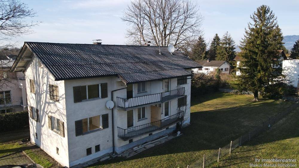 Luftaufnahme des Wohnhauses mit Satteldach, Balkonen und großem Gartenbereich.