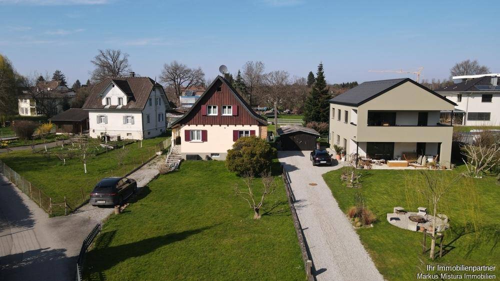 Weitläufige Ansicht von mehreren Wohnhäusern mit großen Grünflächen und Zufahrten.