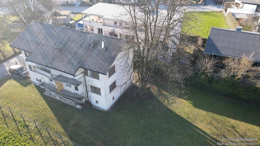 Draufsicht auf das Anwesen mit dem Hauptgebäude und angrenzenden Grünflächen.