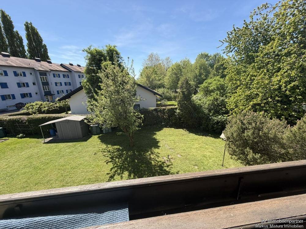 Weitläufiger Blick vom Balkon auf den grünen Garten und die Nachbarschaft.