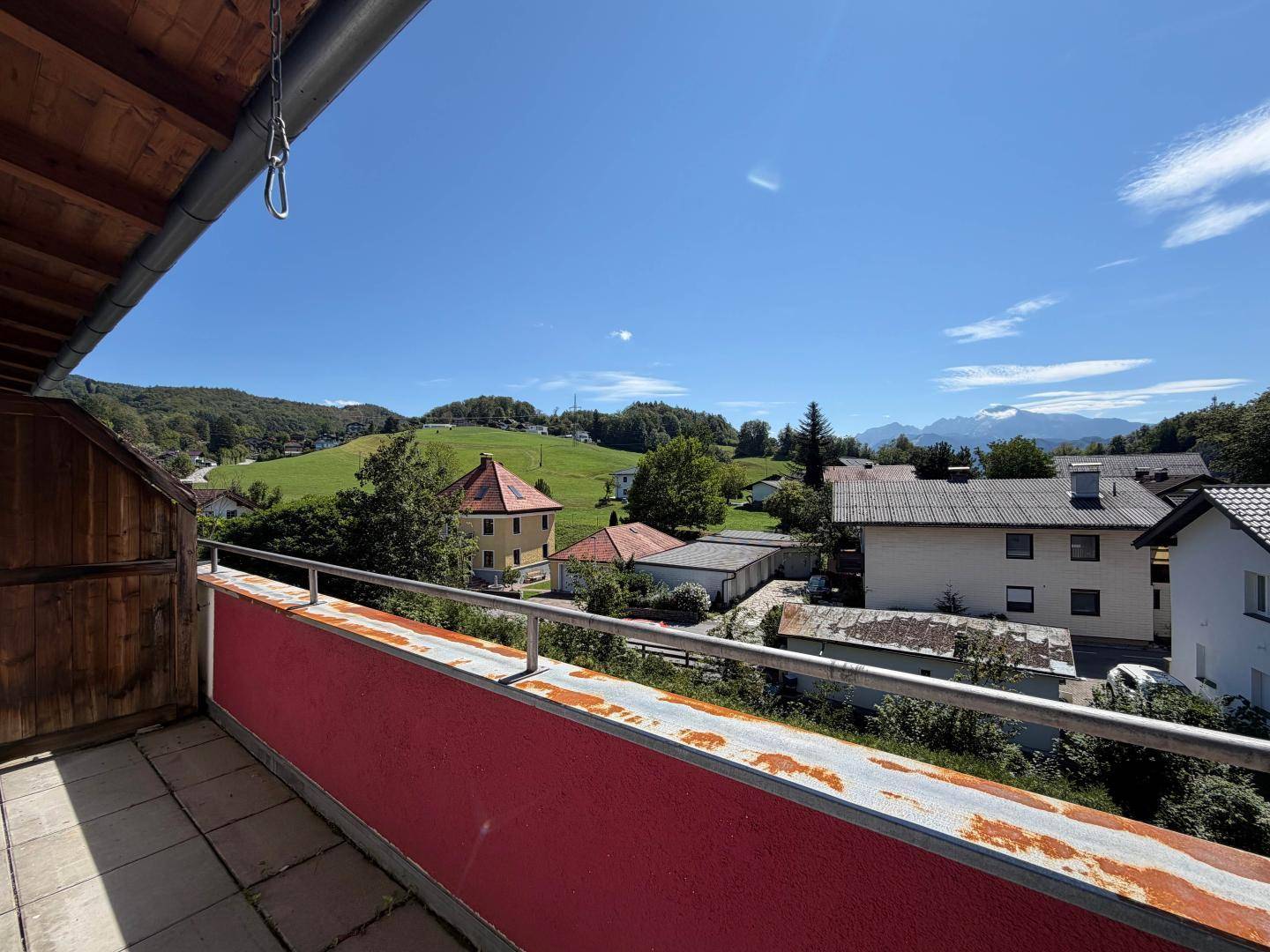 Geräumiger Balkon mit weitem Blick über die grüne Landschaft und die Berge.