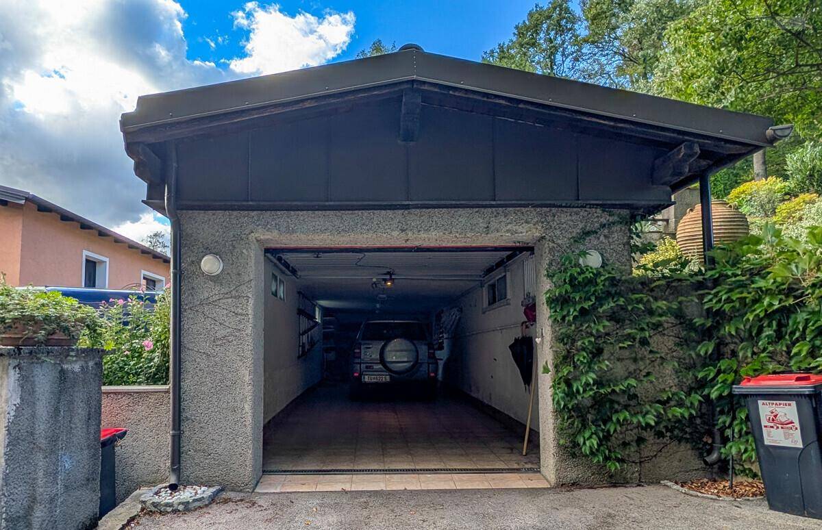 Geräumige Doppelgarage mit offenem Tor und einem geparkten Fahrzeug.