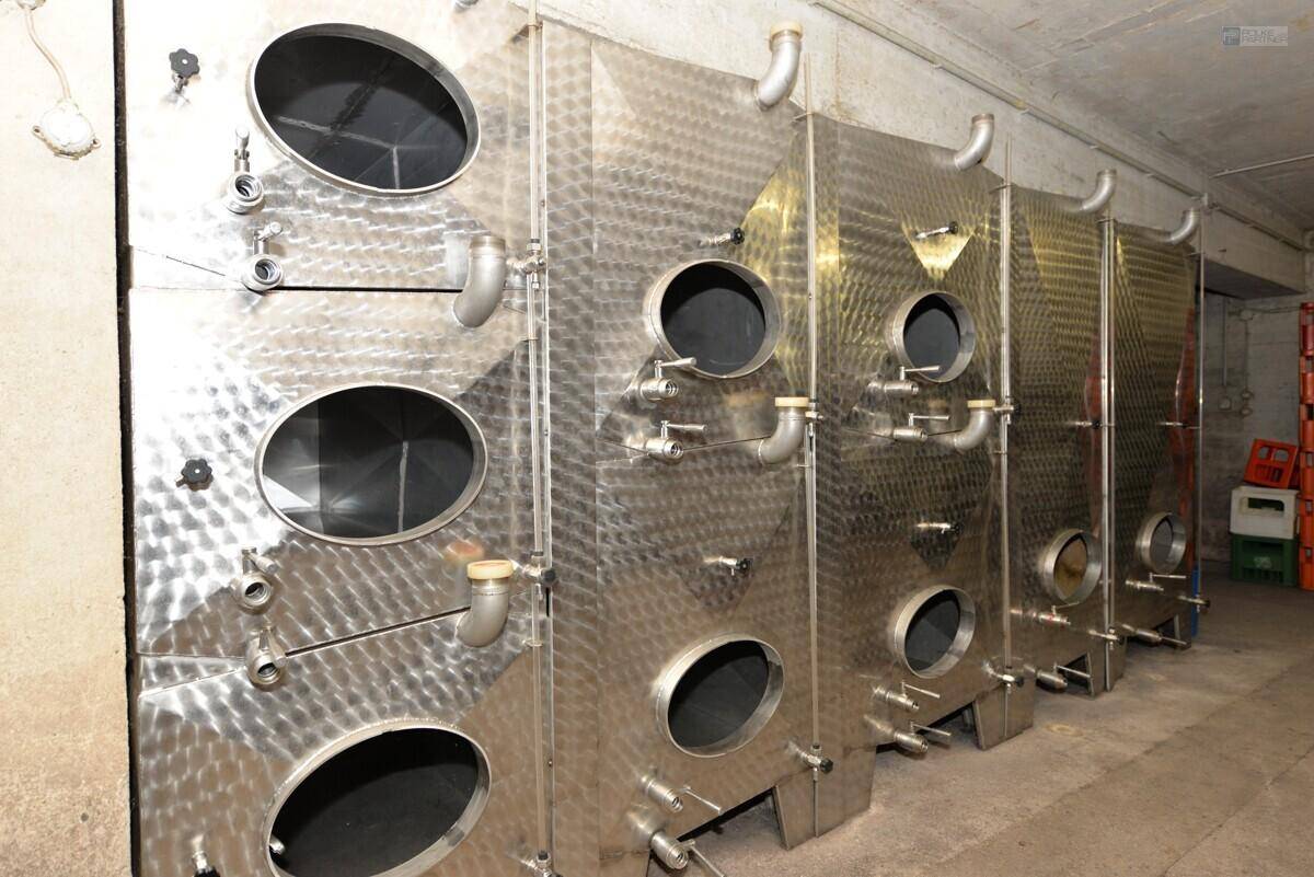 Reihe von großen Edelstahltanks in einem Weinkeller, verwendet für die Weinproduktion.