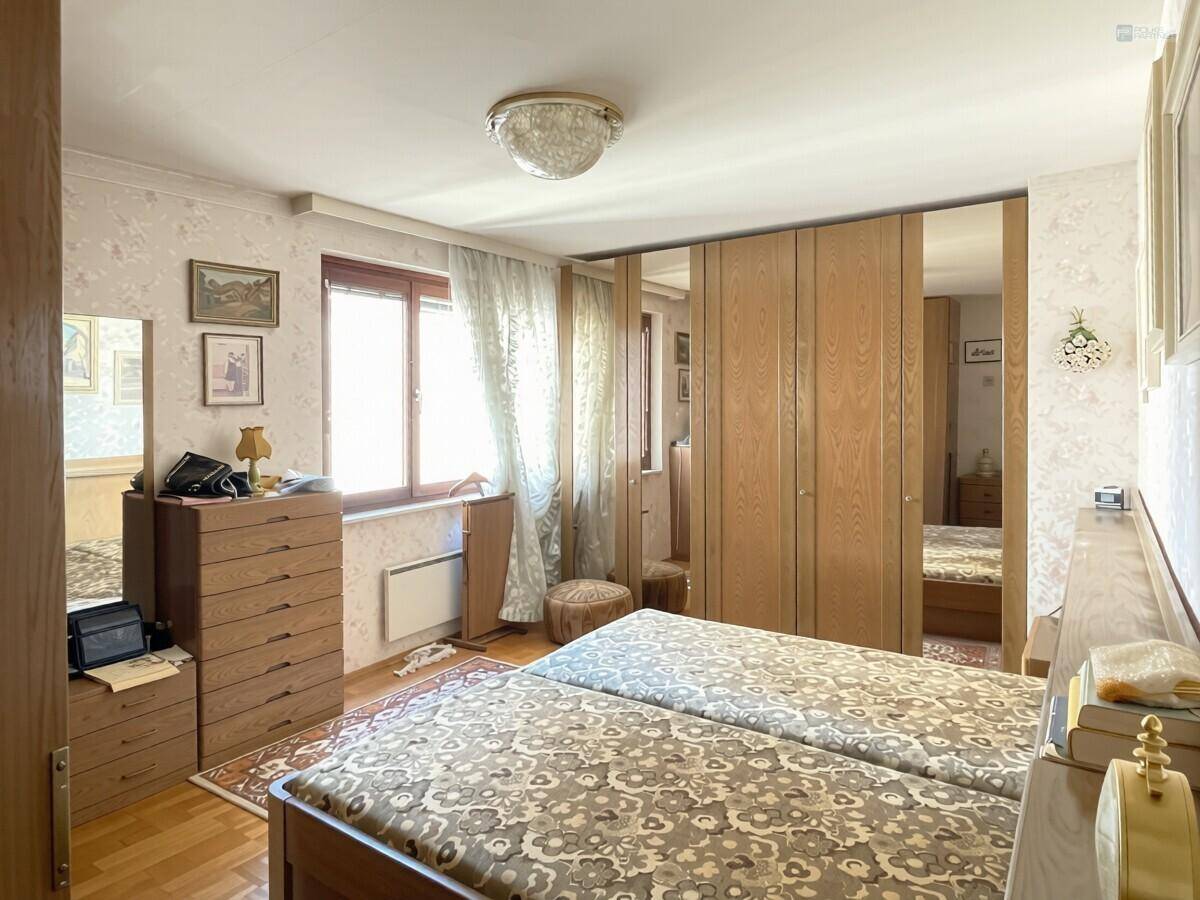 Gemütliches Schlafzimmer mit zwei Einzelbetten, Holzmöbeln und Spiegelschränken.