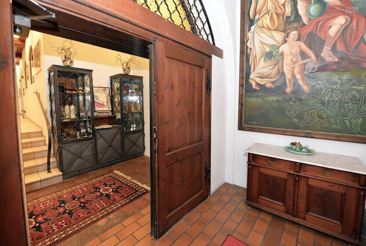 Rustikaler Eingangsbereich mit Terrakotta-Fliesen, Holzmöbeln und einem großen Gemälde an der Wand.