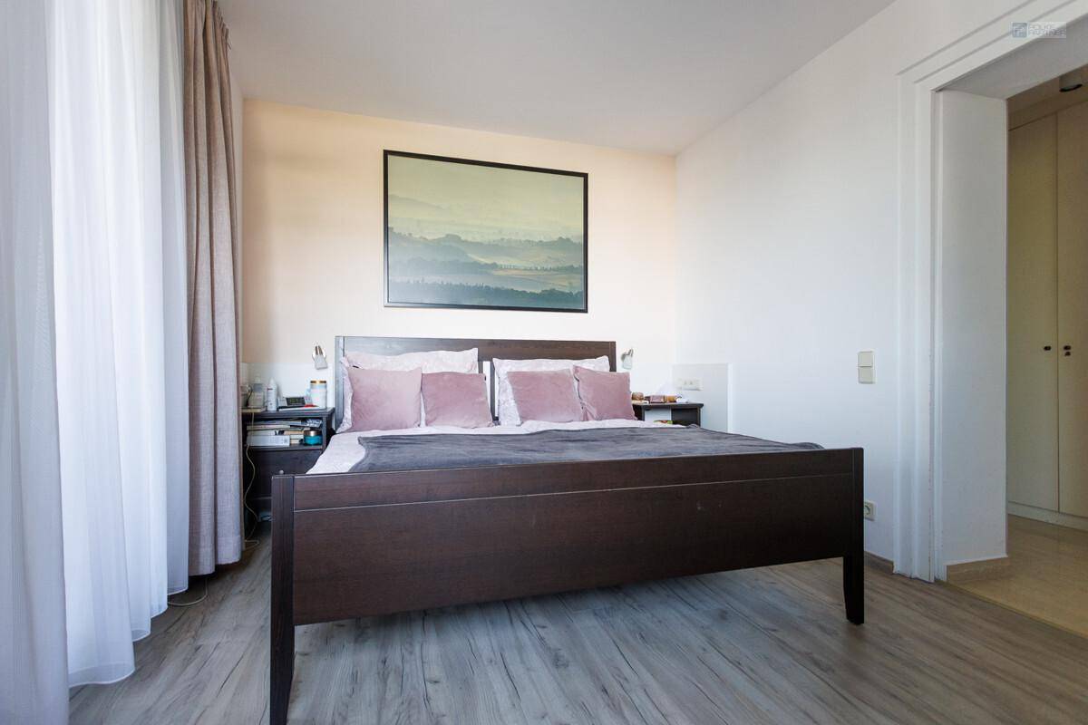 Gemütliches Schlafzimmer mit Doppelbett, Holzboden und schlichtem, modernem Dekor.