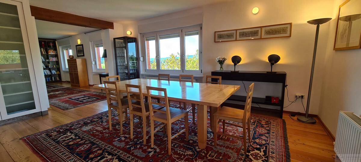 Geräumiger Essbereich mit Holztisch, Stühlen und Blick auf die umliegende Landschaft.