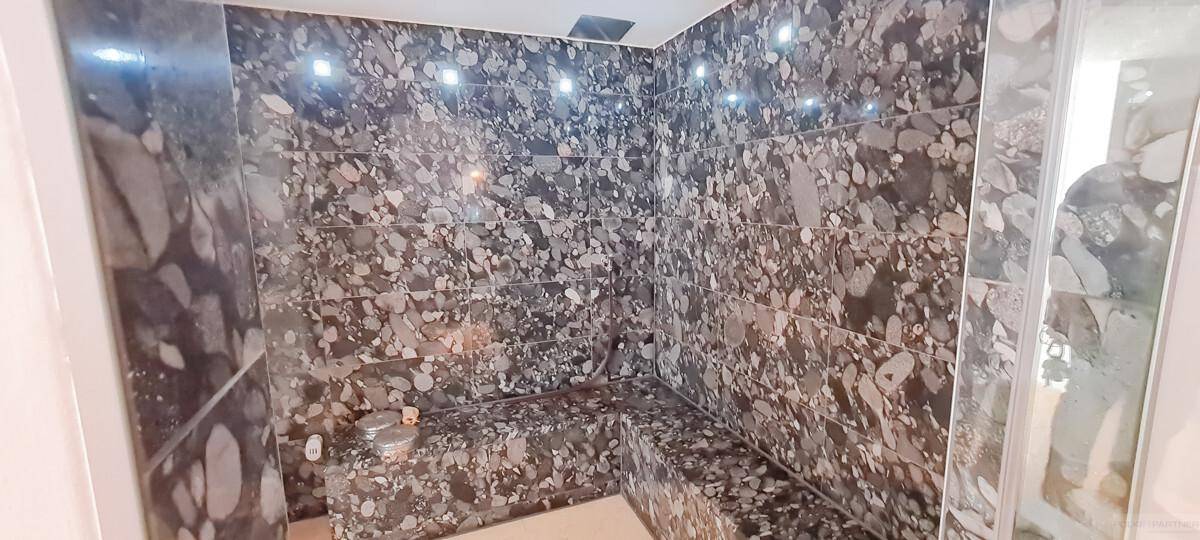 Modernes Badezimmer mit dunklen Fliesen und einer integrierten Dusch- oder Dampfkabine.