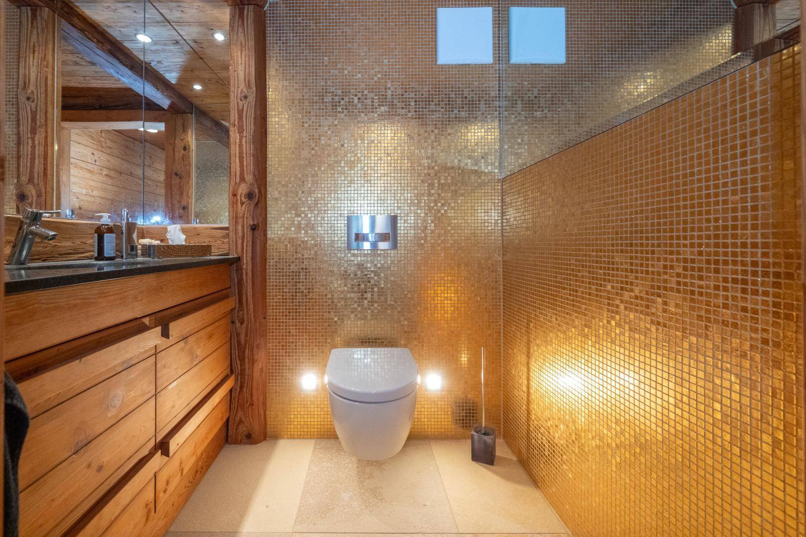 separate Toilette mit Goldmosaikfliesen