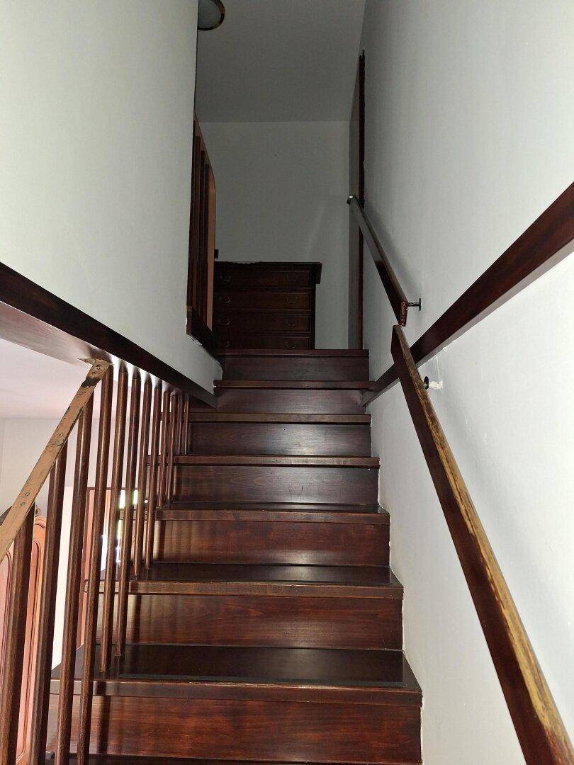 Dunkle Holztreppe führt in das obere Stockwerk des Hauses.