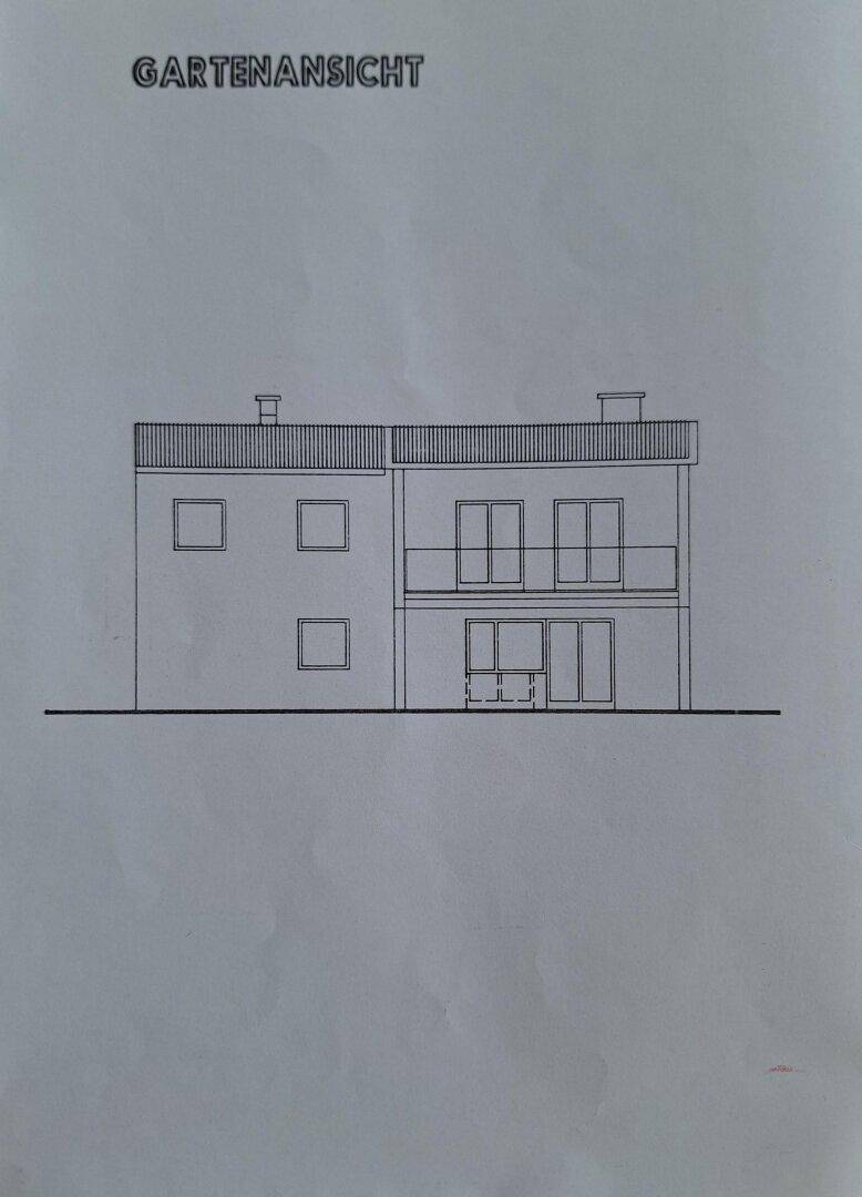 Gartenansicht des Hauses mit Balkon und großen Fensterfronten zum Garten.