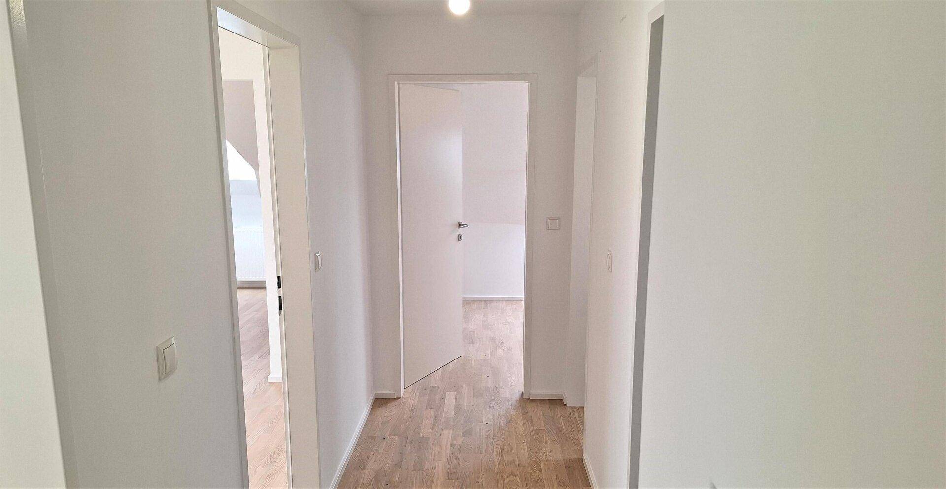 Heller Flur im Obergeschoss mit Parkettboden und Zugang zu den Schlafzimmern und Bädern.