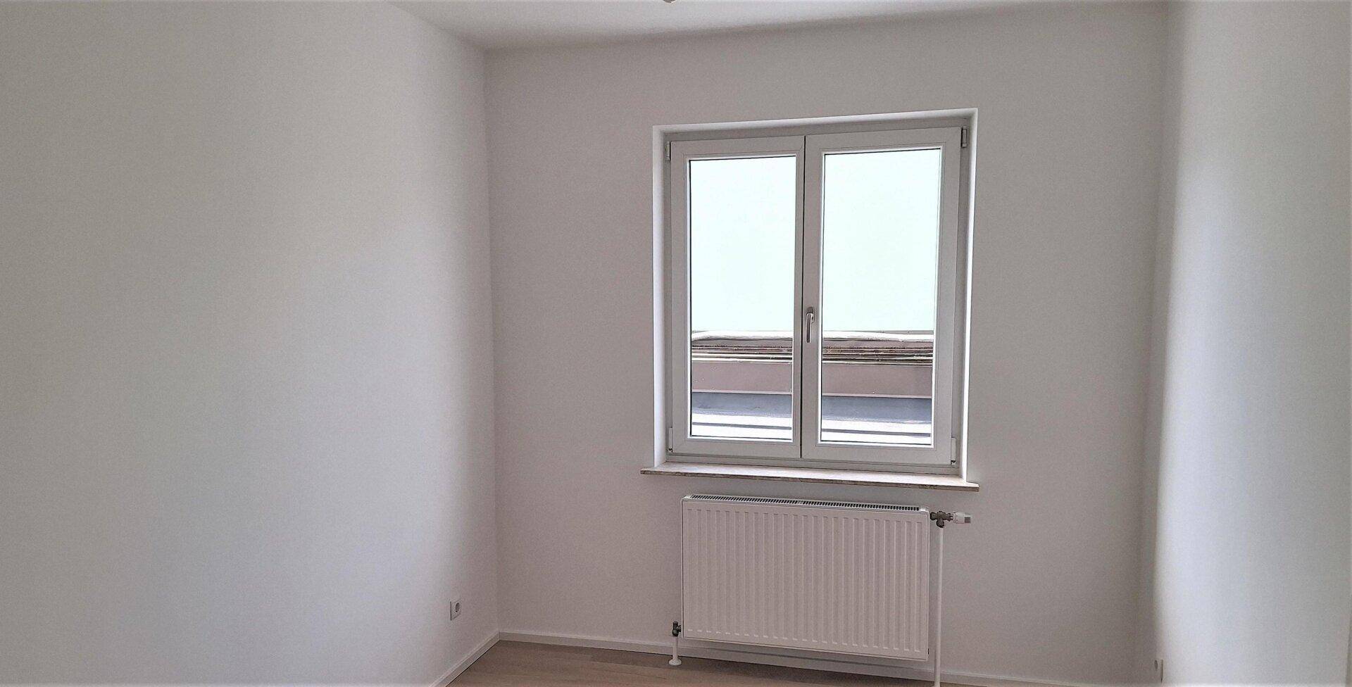 Gemütliches Zimmer mit Parkettboden und einem Fenster, das für ausreichend Helligkeit sorgt.