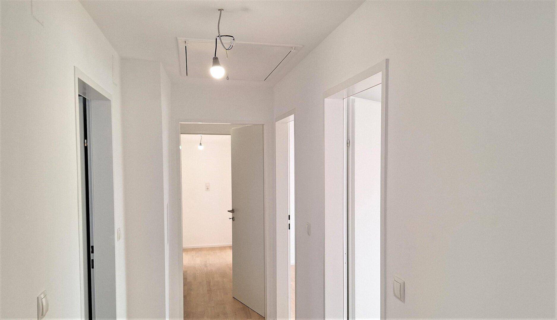 Heller Flur im Obergeschoss mit Parkettboden und Zugang zu den verschiedenen Räumen.