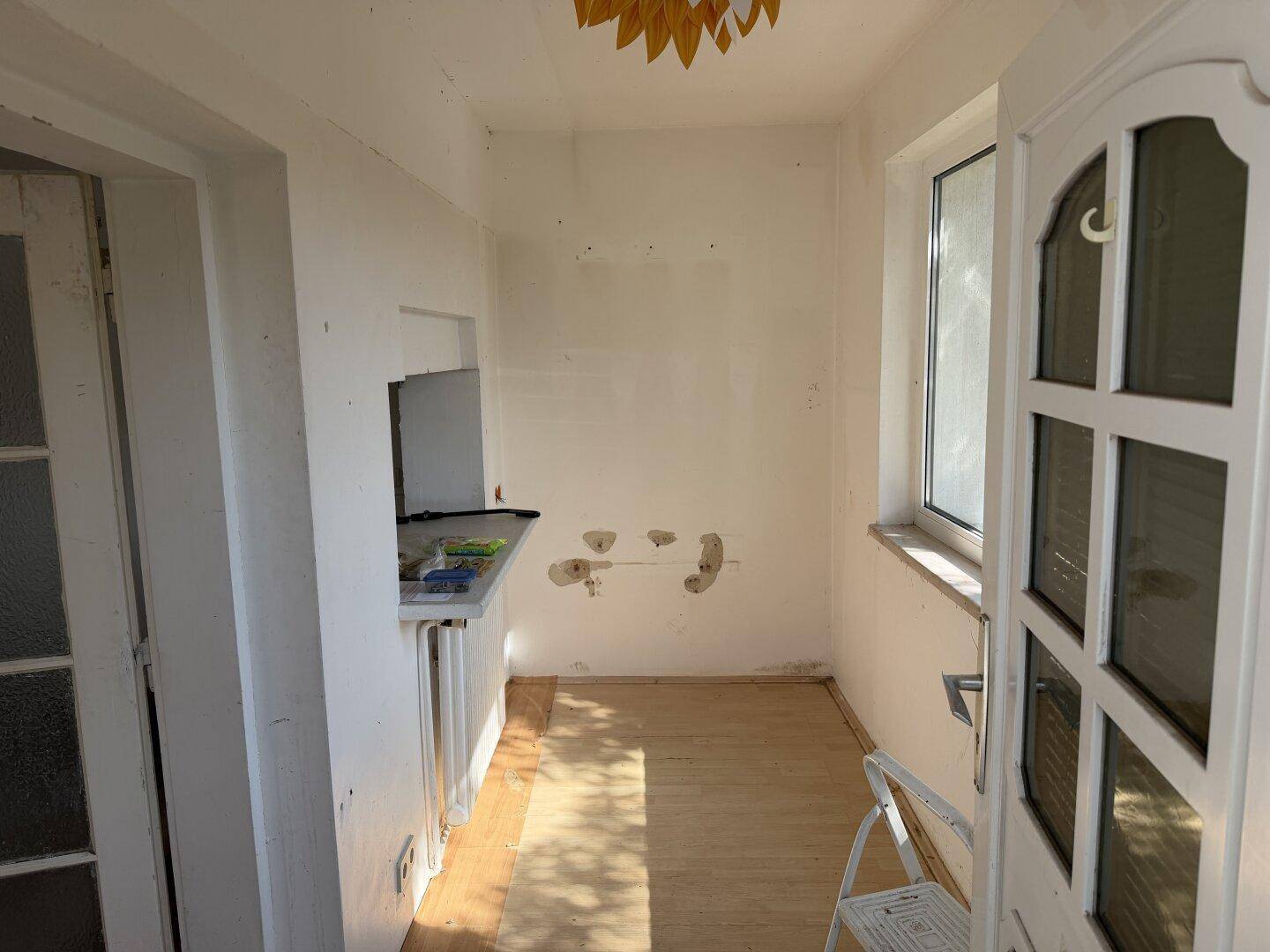 Kleiner Raum im Renovierungszustand mit Fenster und Spuren einer ehemaligen Installation.