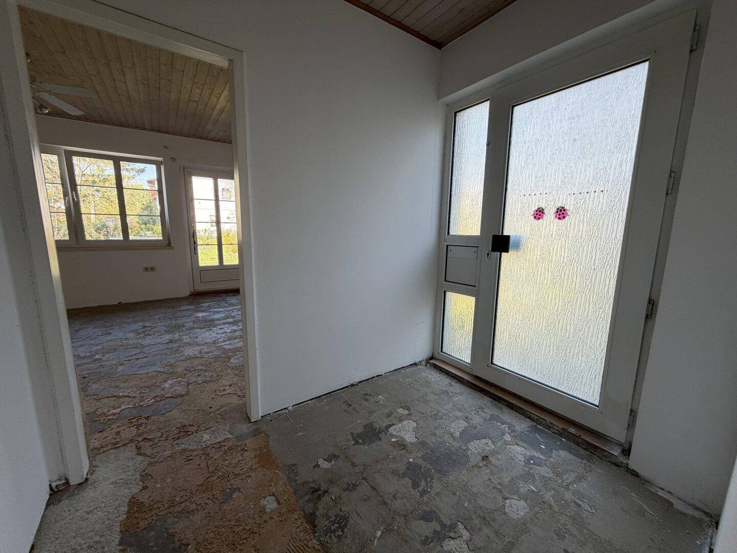 Eingangsbereich oder Flur mit großer Glastür und sichtbaren Renovierungsspuren.