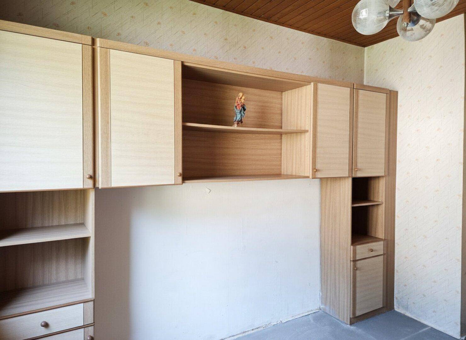 Detailansicht der Einbauschränke in einem hellen Zimmer mit Holzdecke.