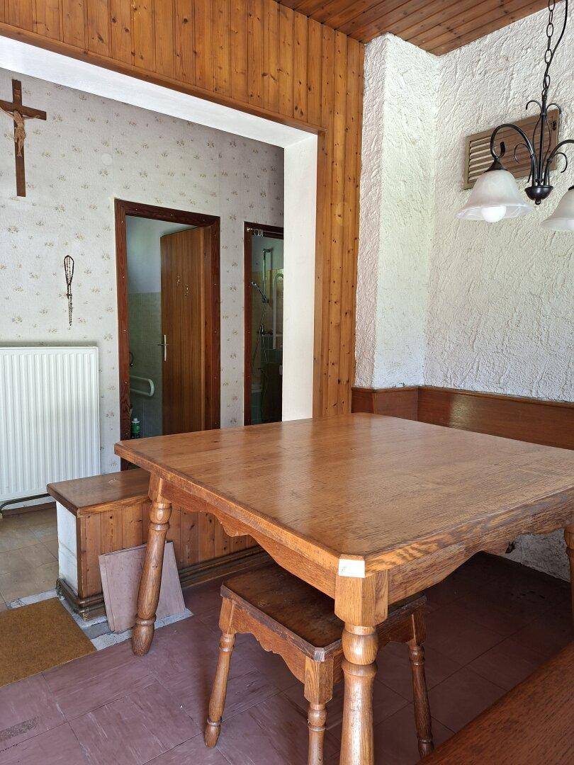 Essbereich mit Holztisch und Blick in den Flur, geprägt von Holzvertäfelung.