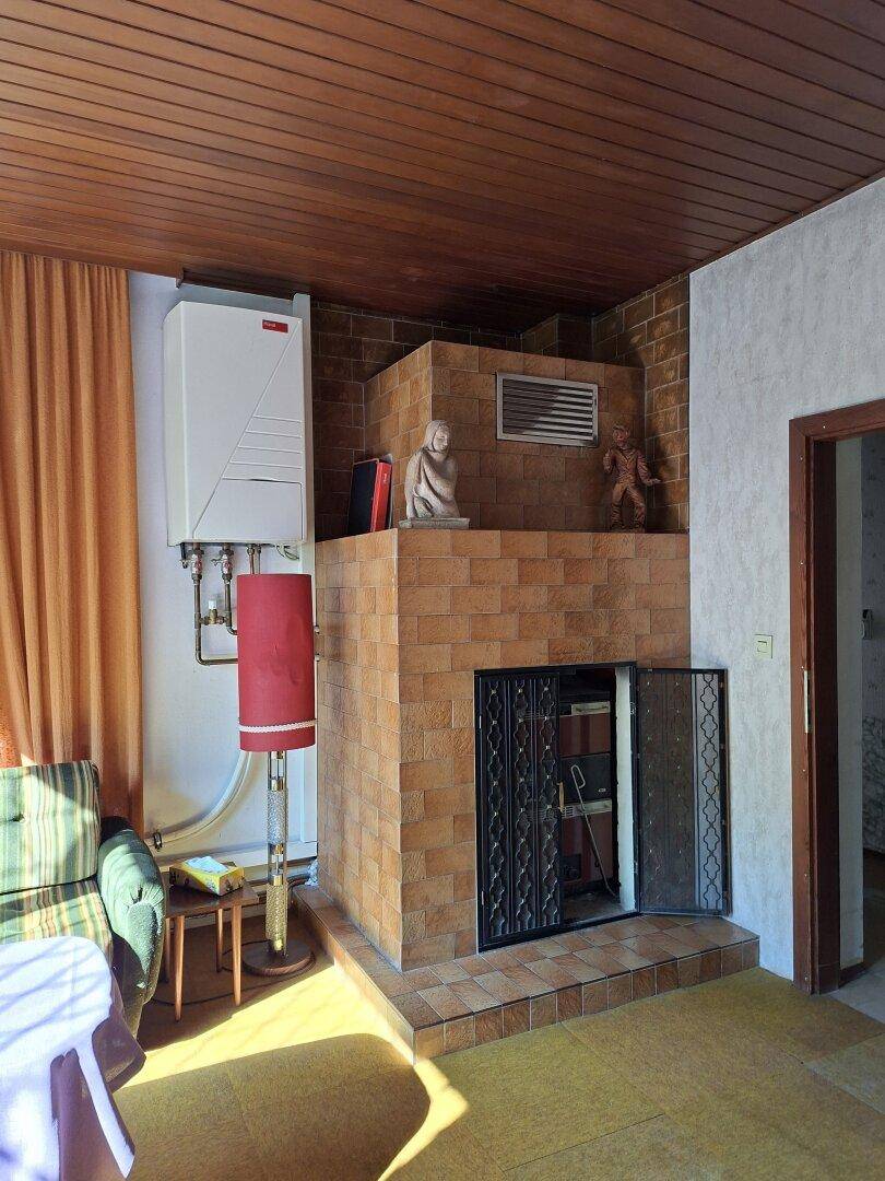 Gemütlicher Wohnbereich mit Kamin, Heizung und traditioneller Einrichtung.