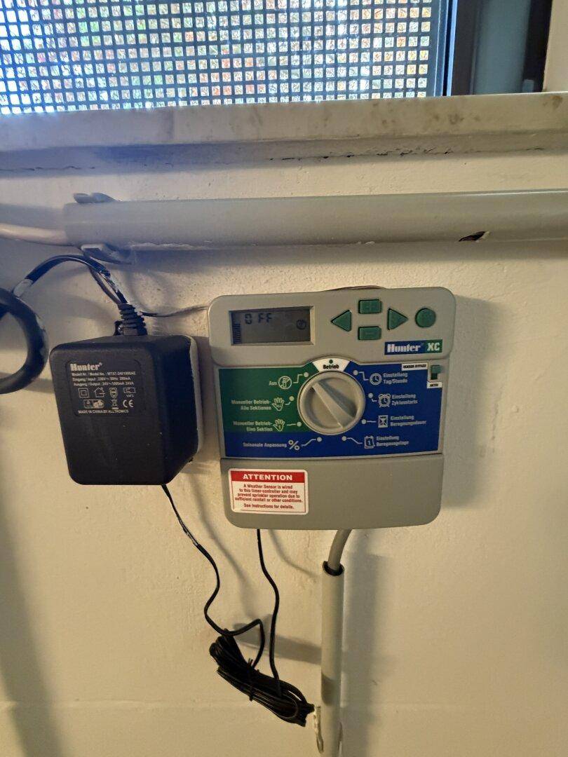 Bewässerungssteuerungssystem von Hunter XC an der Wand montiert, wahrscheinlich in einem Hauswirtschaftsraum.