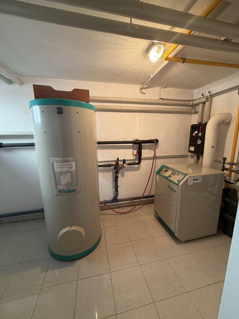 Heizungsraum im Keller mit Warmwasserspeicher und Heizungsanlage.