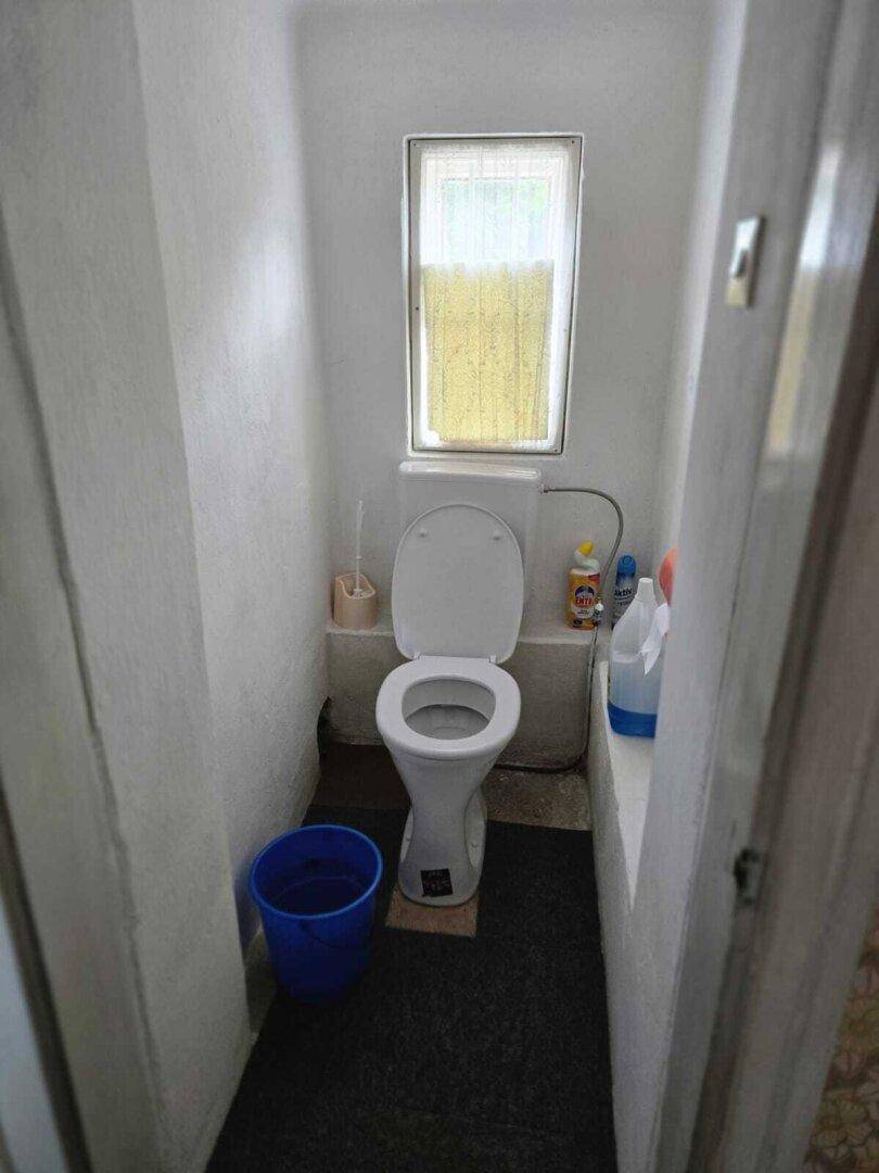 Kleines WC mit Fenster, Toilette und einfacher Ausstattung.
