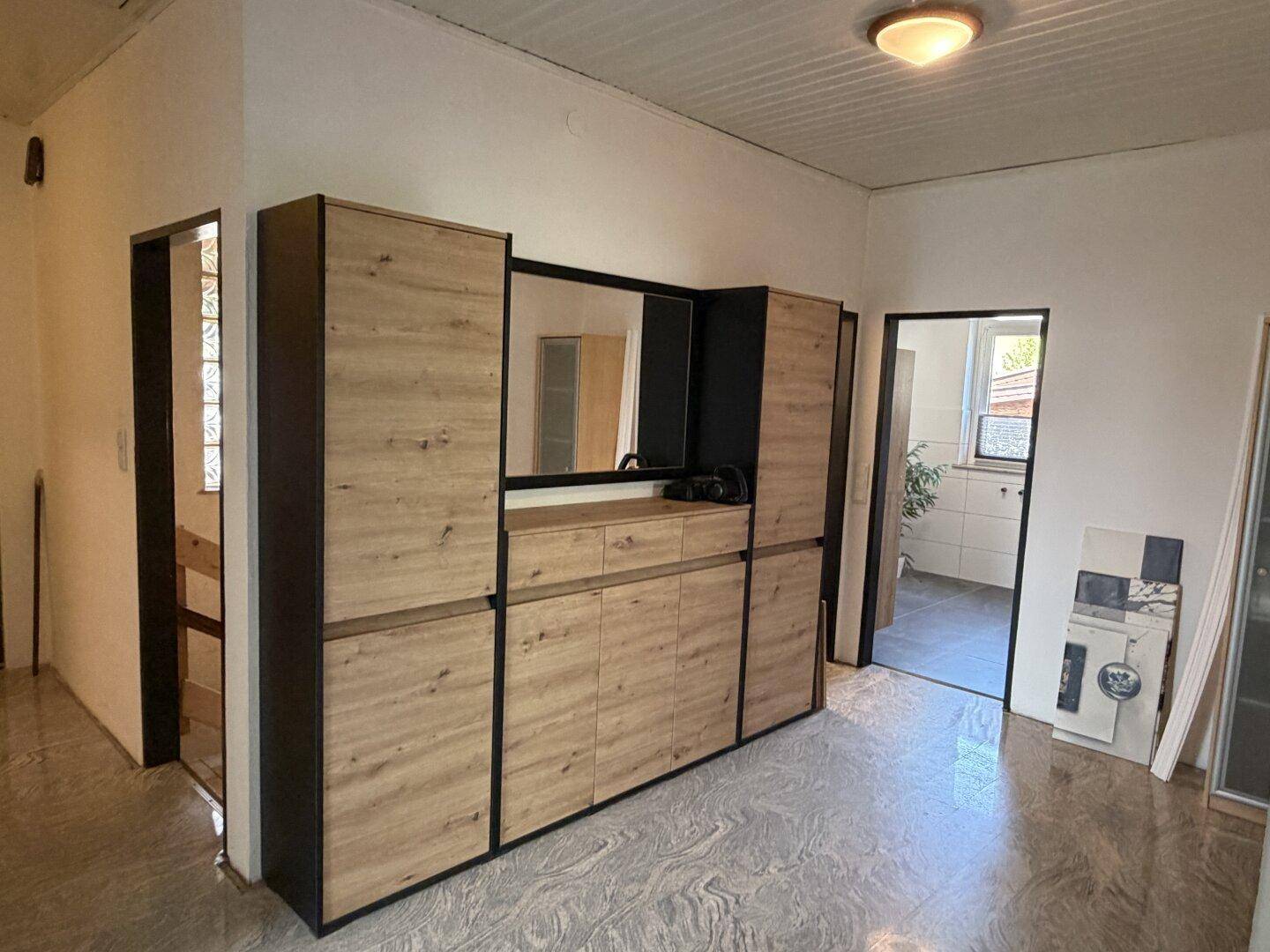 Heller Flur mit modernem Einbauschrank und gemustertem Fliesenboden.