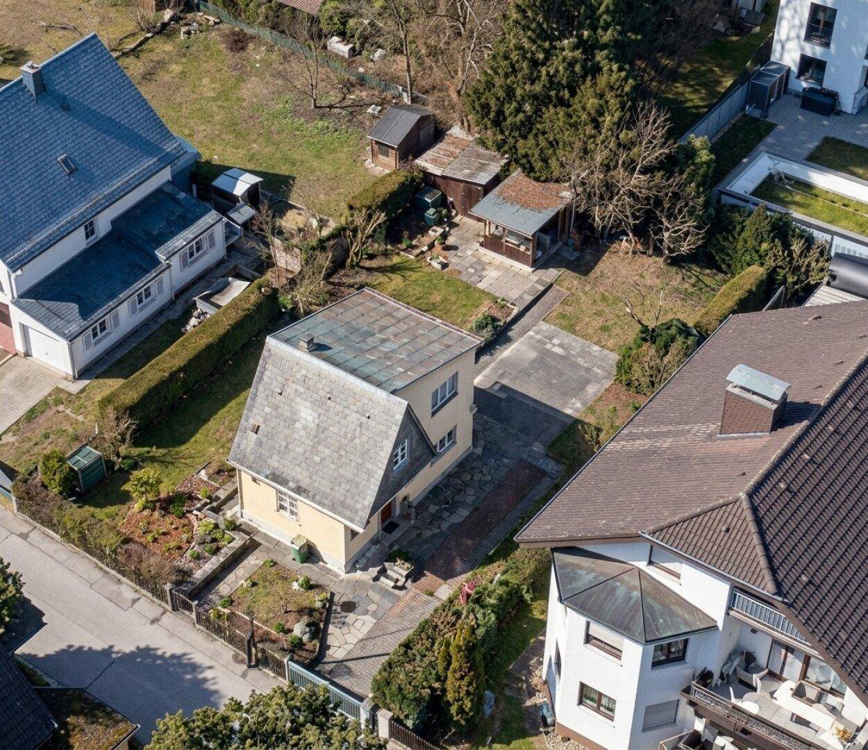 Luftaufnahme des Grundstücks mit Einfamilienhaus, Garten und mehreren Nebengebäuden.
