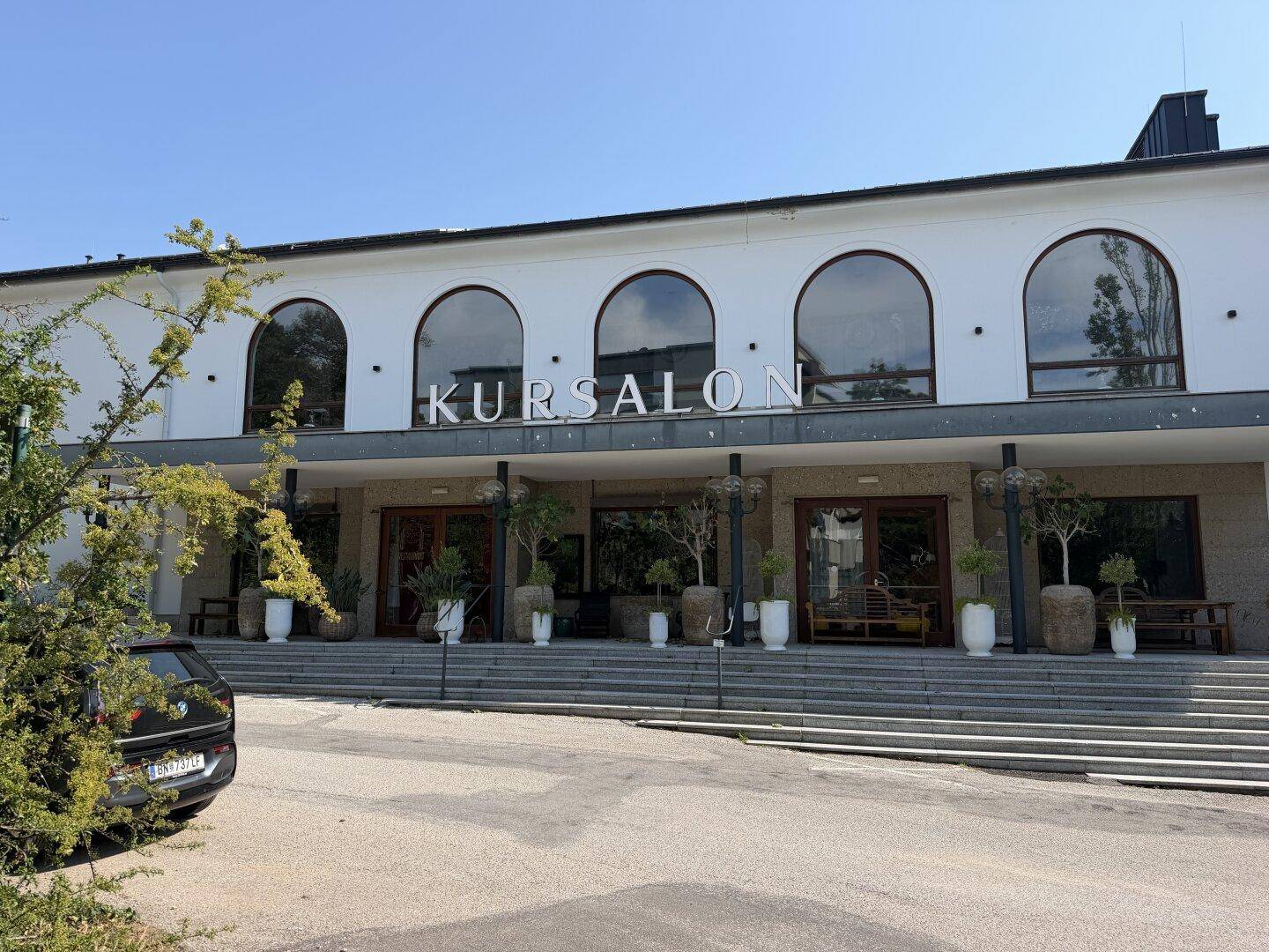 Die moderne Fassade des Kursalons mit großen Rundbogenfenstern und breiter Treppe.