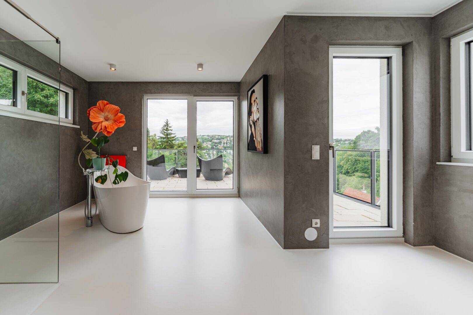 Modernes Badezimmer mit freistehender Badewanne, begehbarer Dusche und großen Fenstern mit Ausblick.