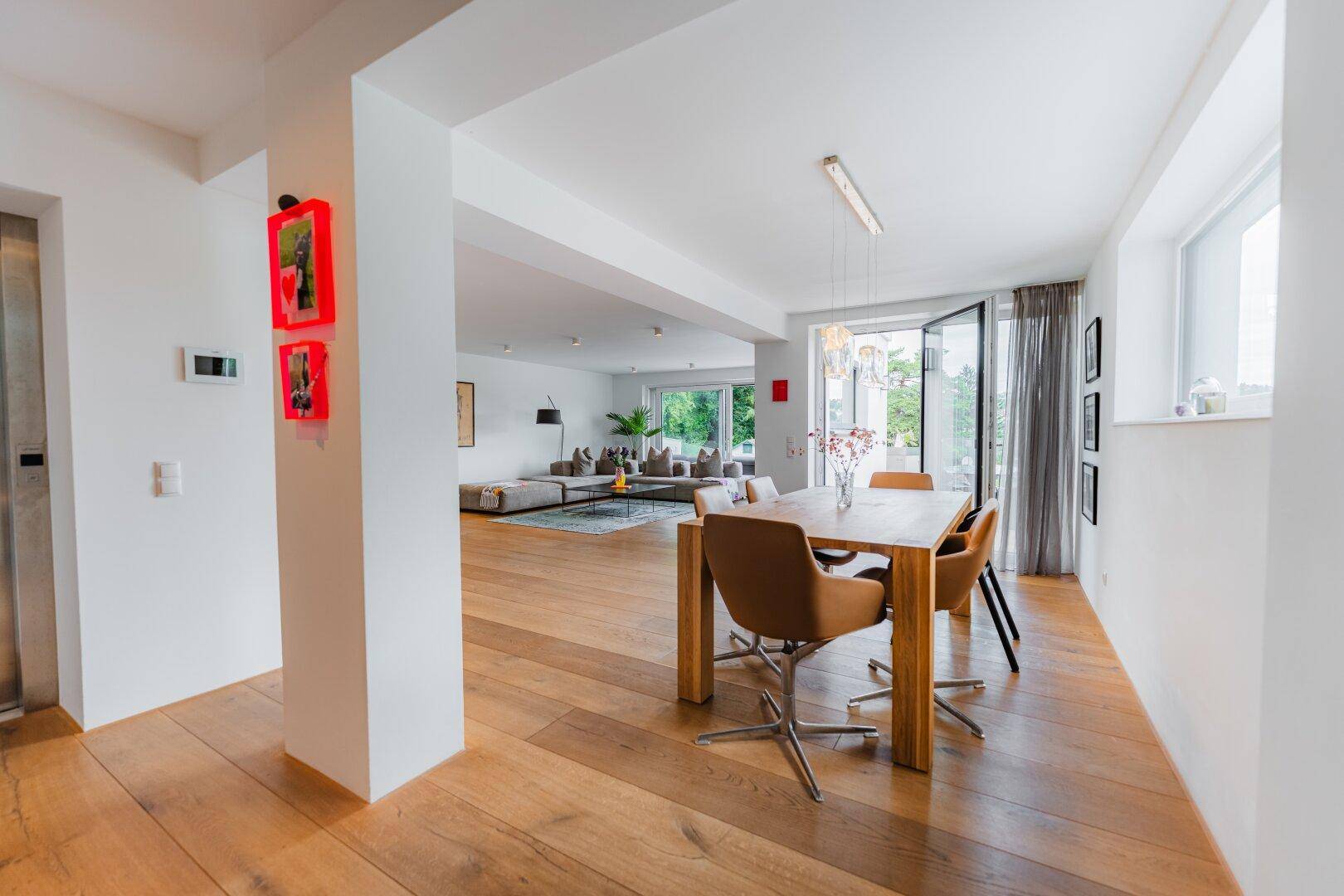 Offener Wohn- und Essbereich mit elegantem Holzboden und moderner Einrichtung.