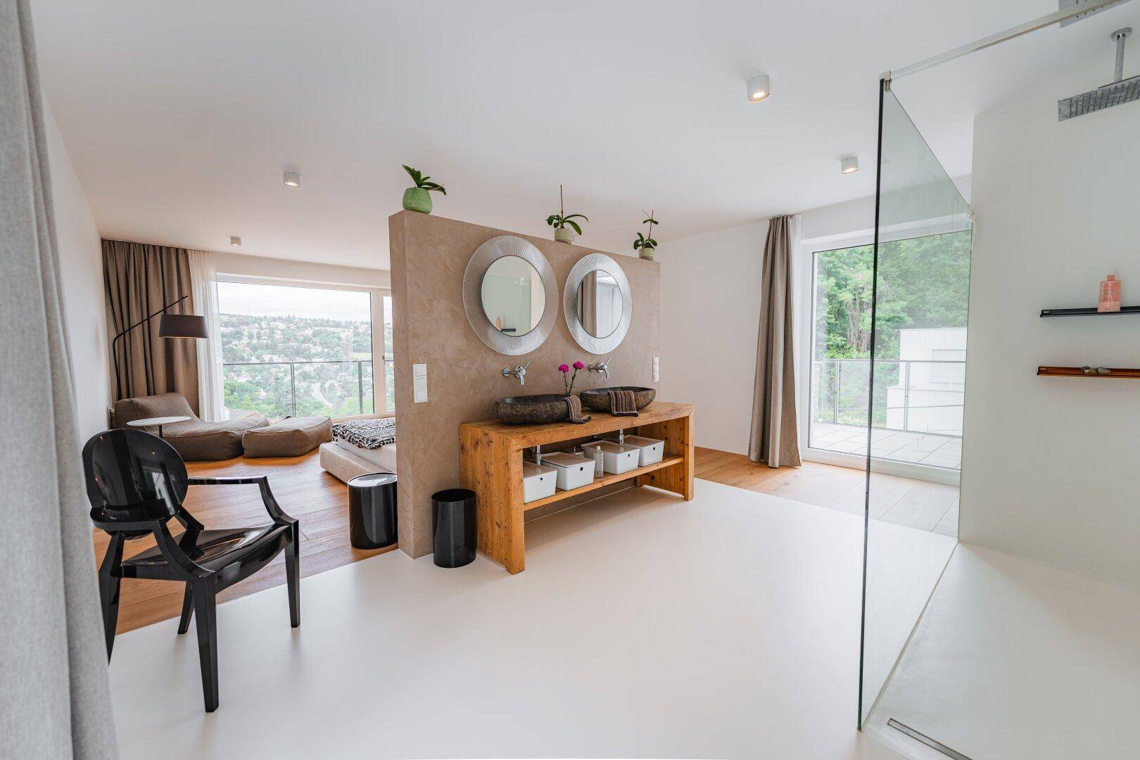Offener Schlaf- und Badebereich mit Doppelwaschbecken, begehbarer Dusche und Panoramablick.