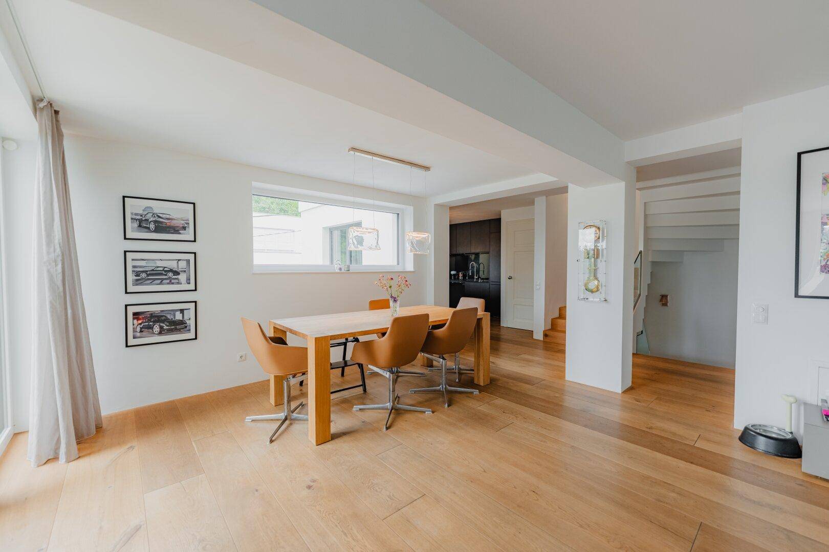 Heller Essbereich mit Holztisch und Stühlen, integriert in den offenen Wohnraum.