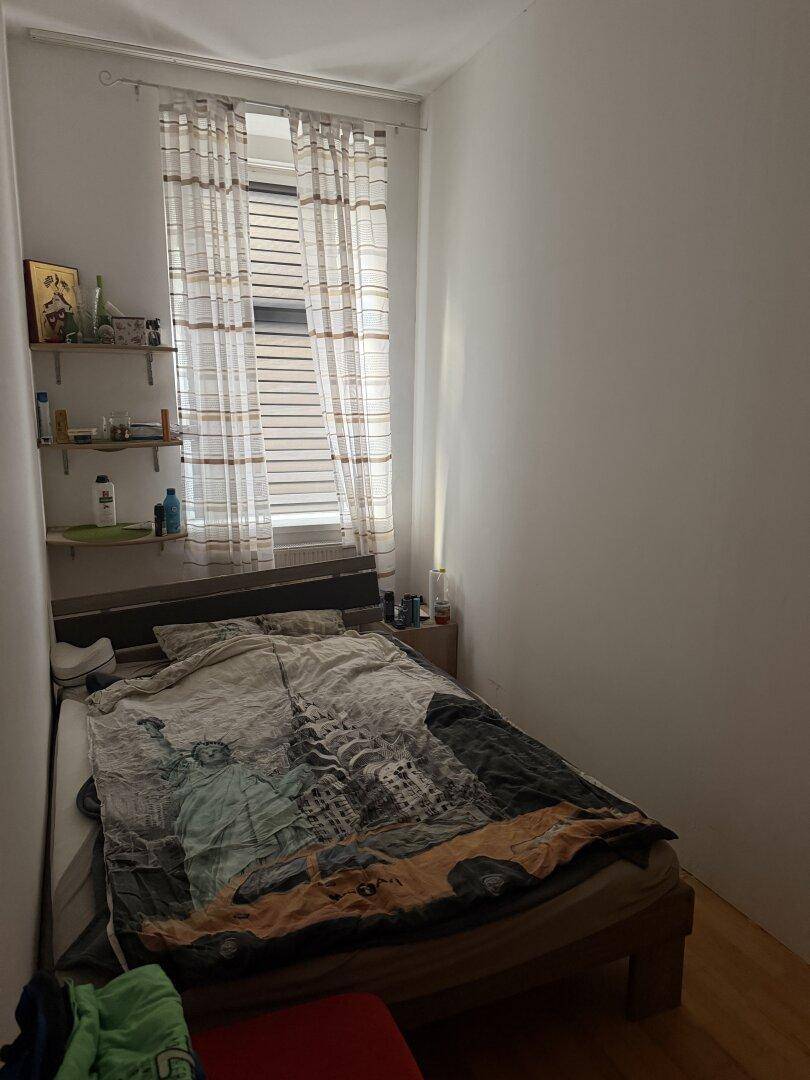 Helles Schlafzimmer mit Einzelbett, Nachttisch und Fenster, ideal für Gäste oder Kinder.