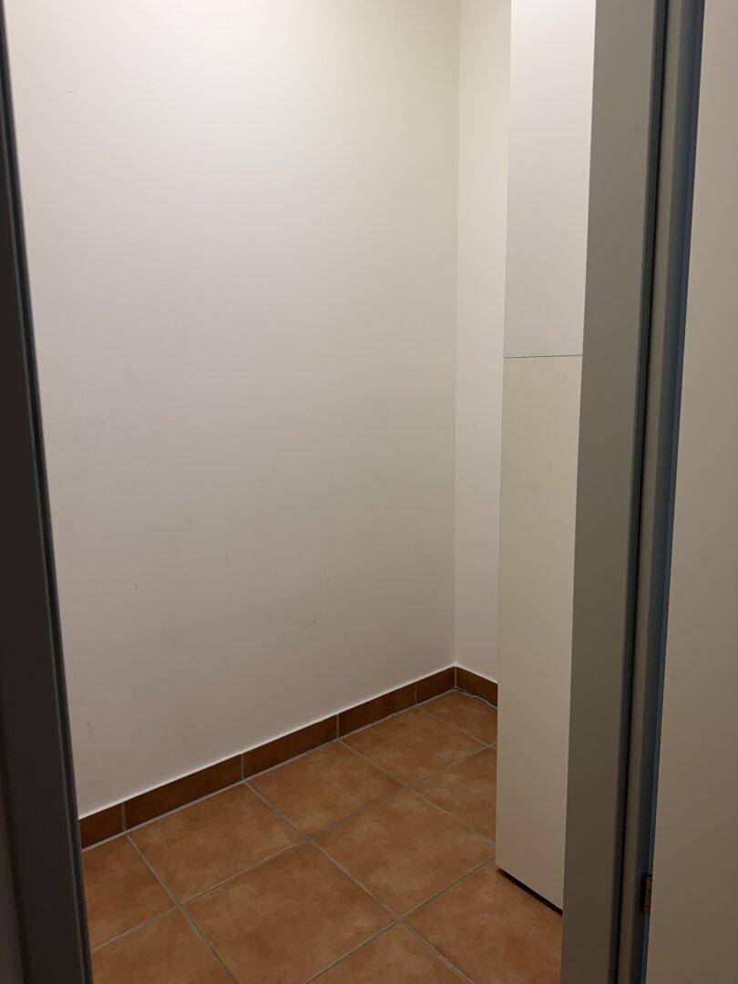 Kleiner Abstellraum mit Fliesenboden und weißen Wänden, ideal für Lagerung.