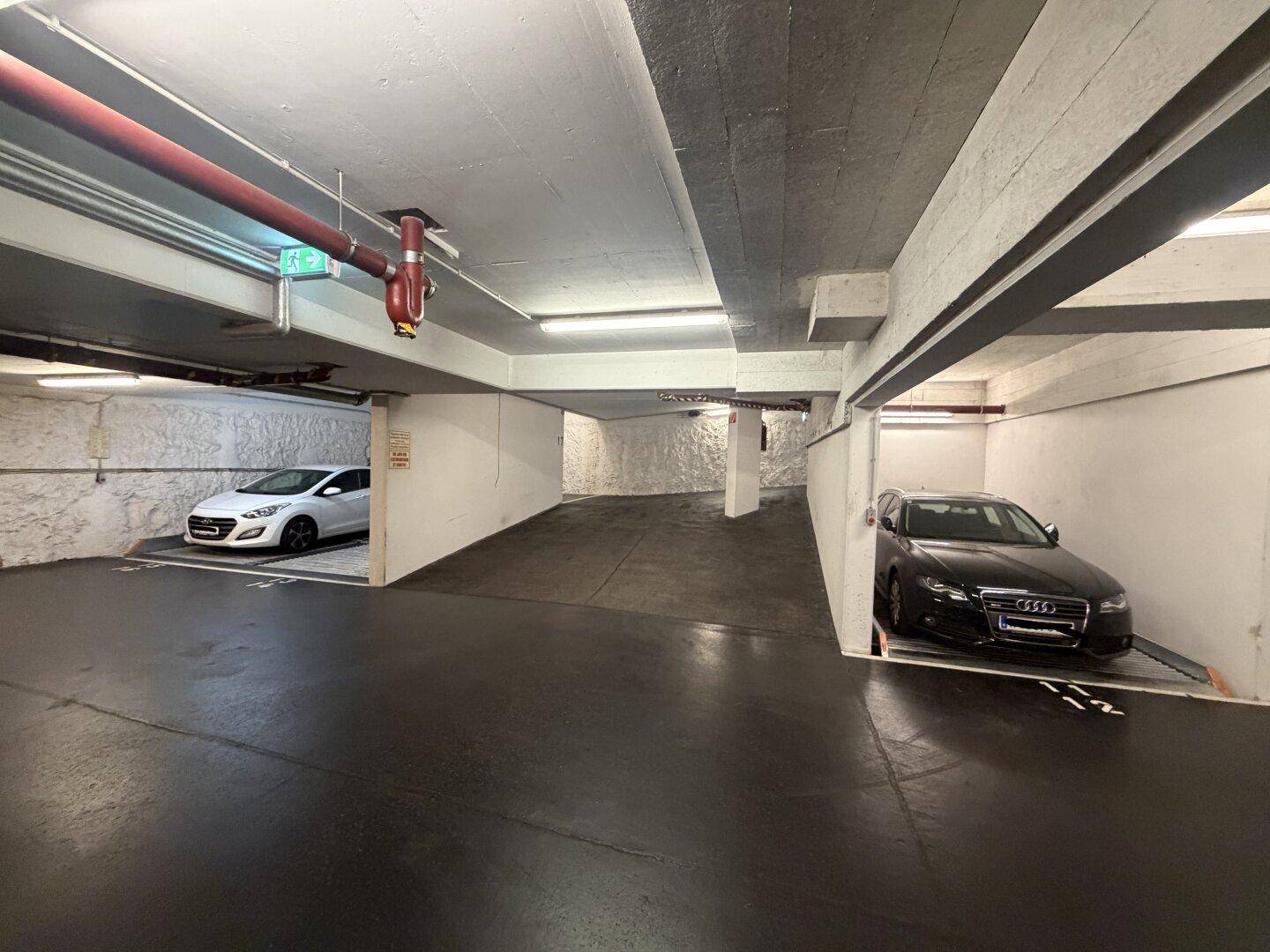 Tiefgarage mit Betonwänden und Beleuchtung, bietet sichere Parkmöglichkeiten.