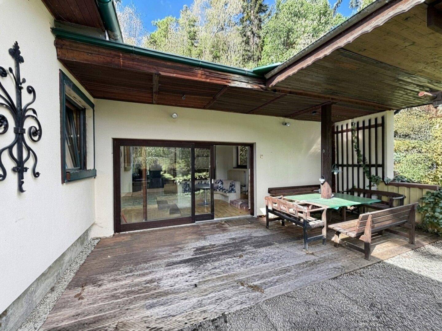 Geräumige überdachte Terrasse mit Holzdeck und direktem Zugang zum Innenbereich.