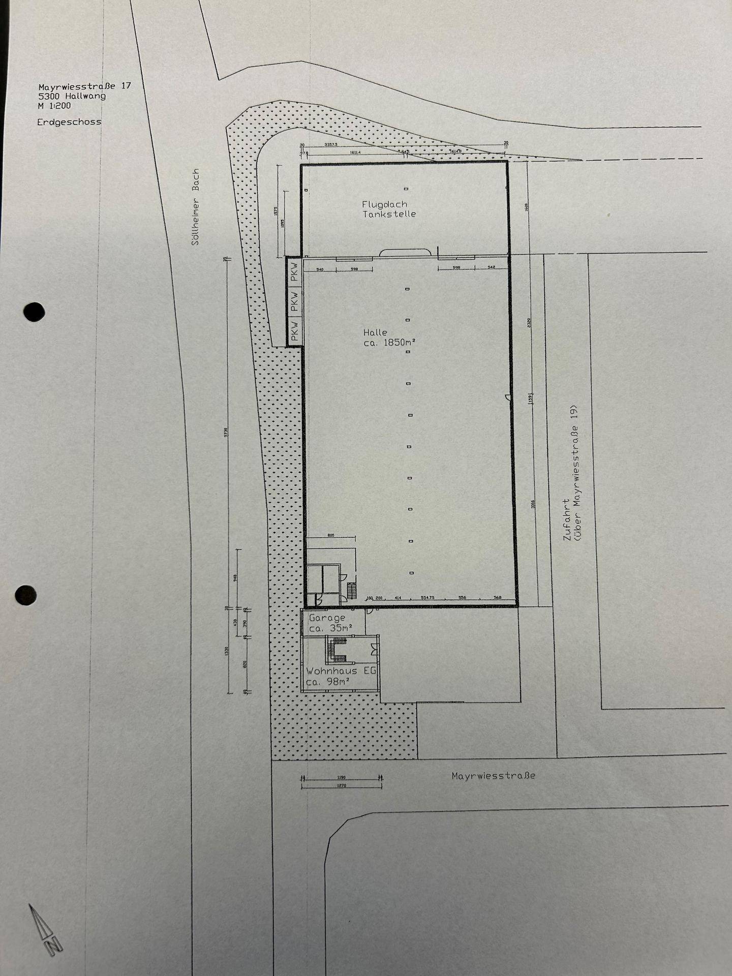 Grundriss des Erdgeschosses mit einer großen Halle, Tankstelle und Bürobereichen.