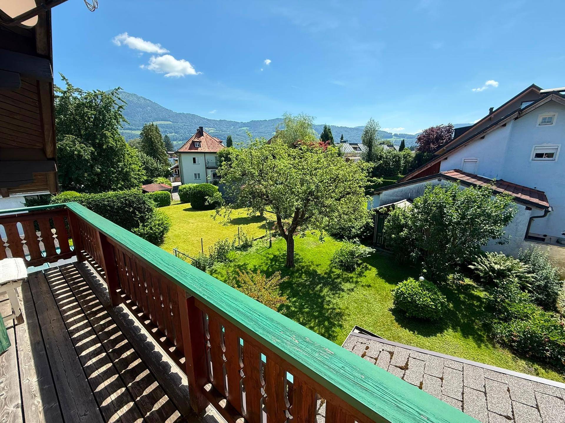 Balkon mit weitem Blick über den grünen Garten, Berge und die Landschaft.