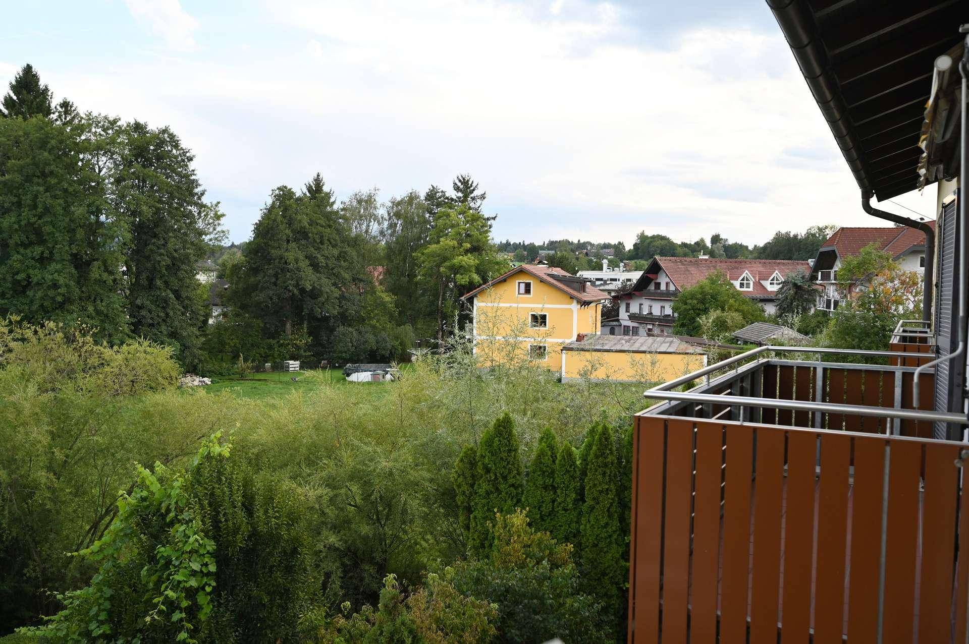 Balkon mit weitem Blick ins Grüne und auf die umliegenden Häuser.