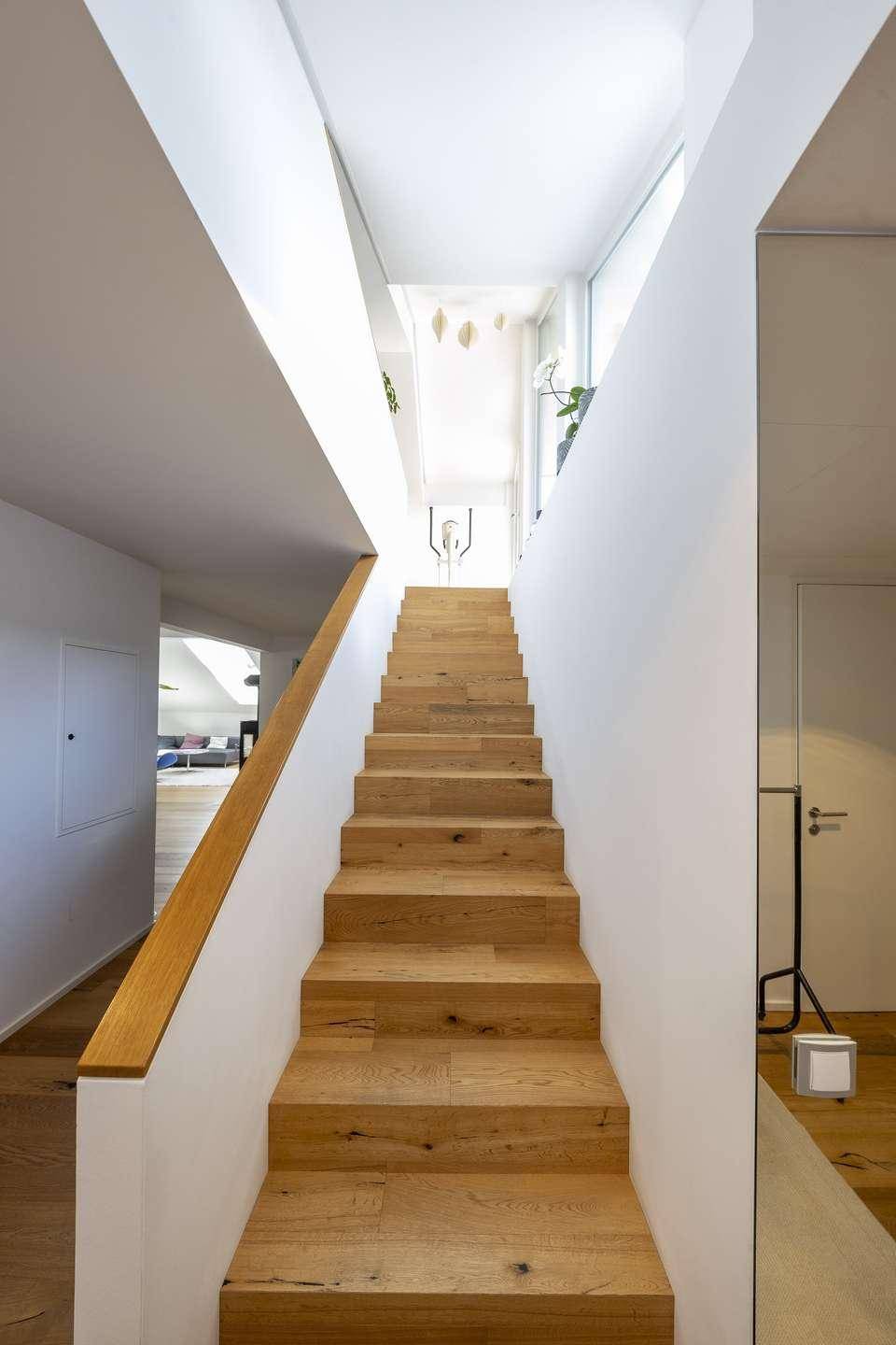 Helle Holztreppe mit modernem Design, die zu den oberen Etagen führt.