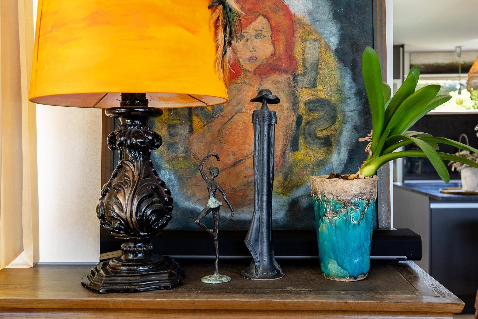 Detailaufnahme von dekorativen Elementen und einer Lampe auf einem Sideboard.