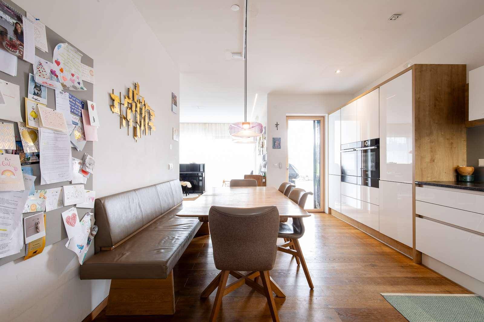 Offene Küche mit Essbereich, Holzboden und Zugang zum Wohnzimmer.