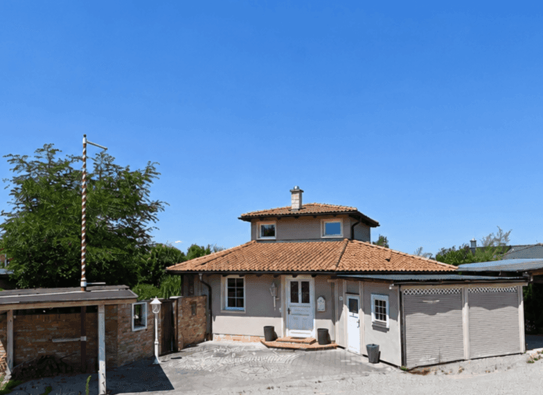 Charmantes Einfamilienhaus mit traditionellem Ziegeldach und gepflastertem Vorplatz.