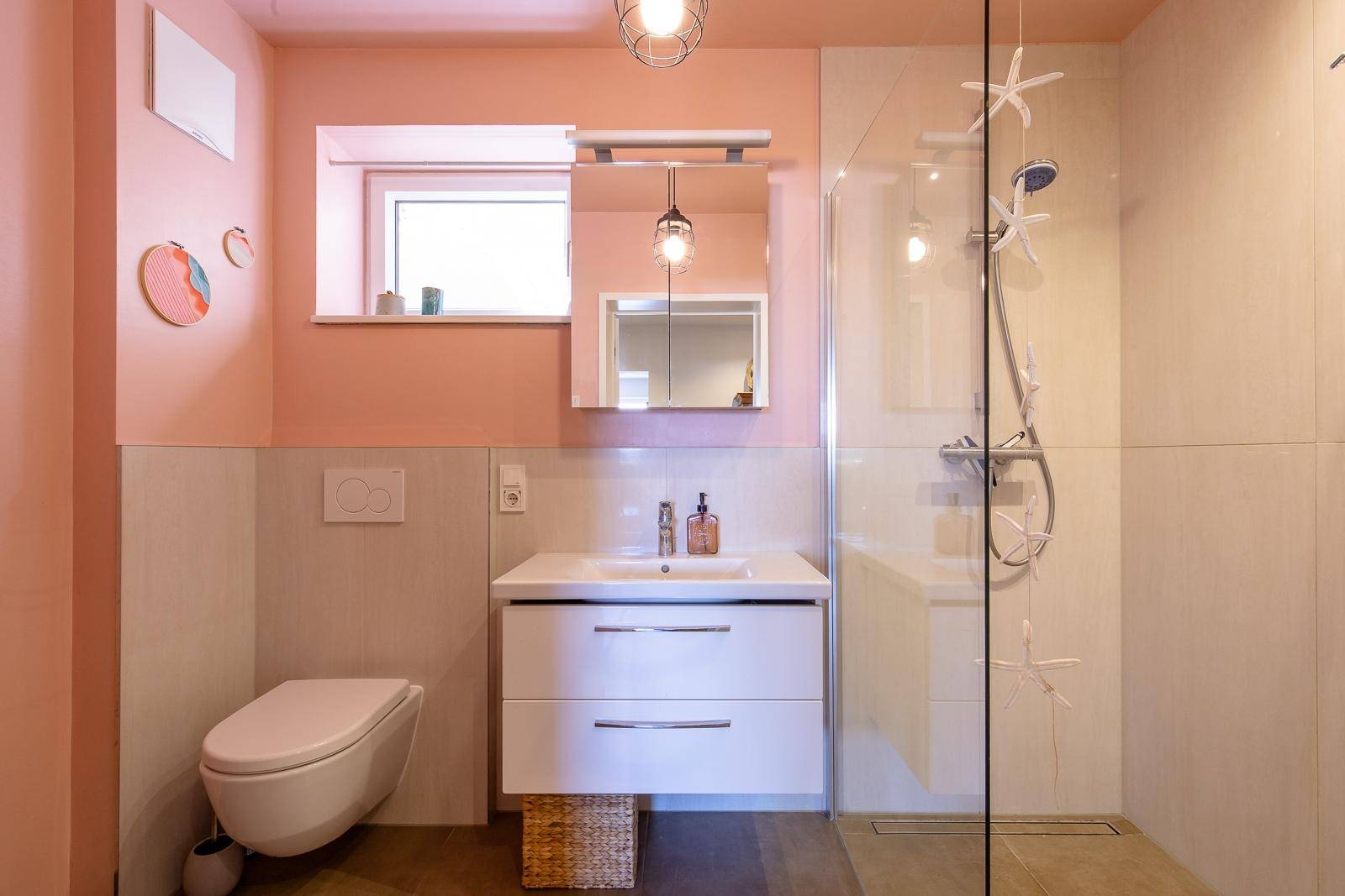 Modernes Badezimmer mit begehbarer Dusche, Einzelwaschbecken und Fenster in Pastellfarben.