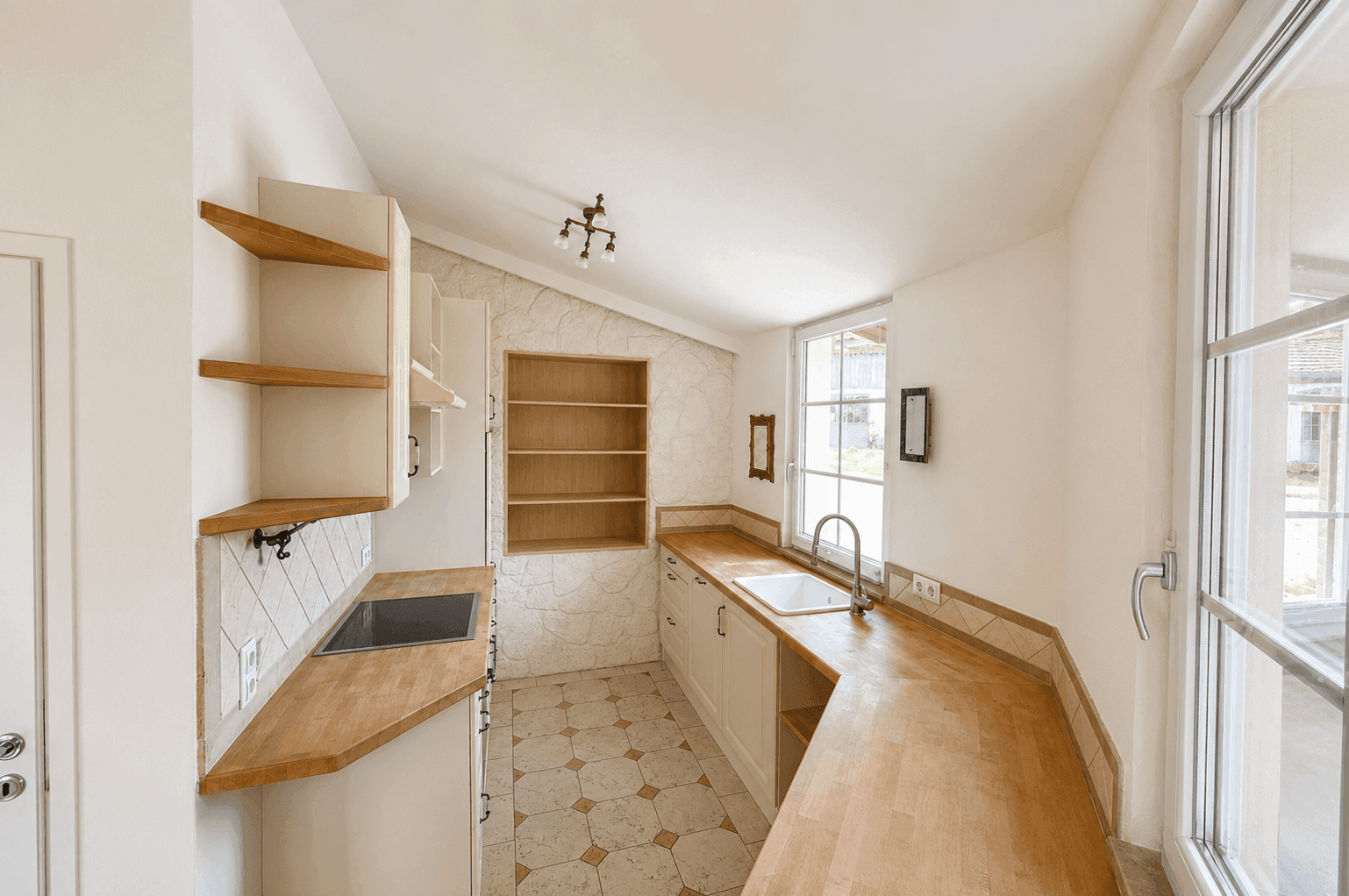 Traditionelle Küche mit hellen Holz-Arbeitsplatten, weißen Schränken und Fliesenboden.